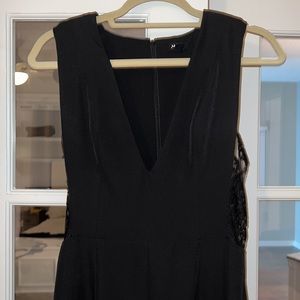 NDB full length black dress with cutout lace sides and padded shoulders.